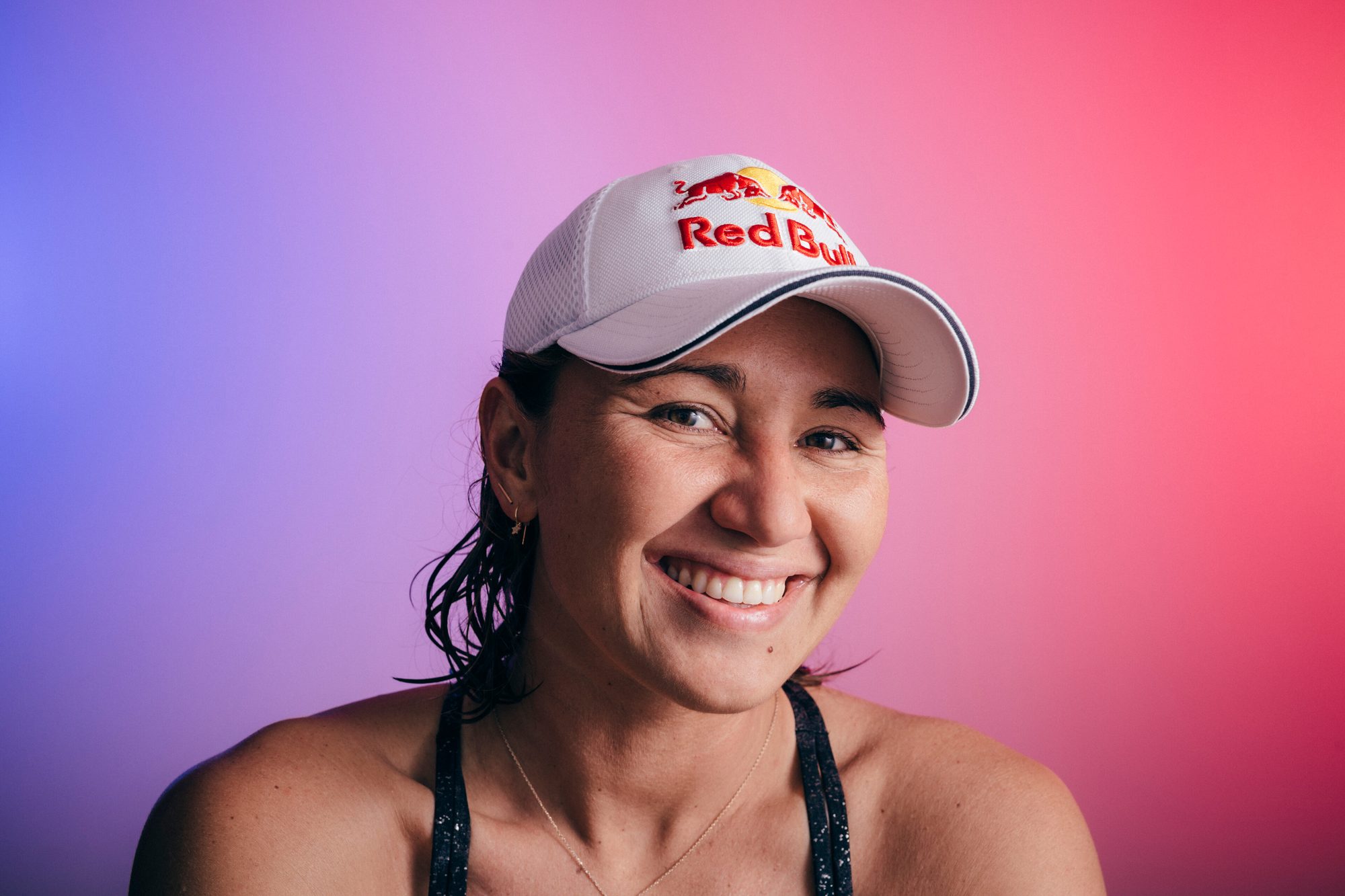 Carissa Moore smiling in a white Red Bull cap